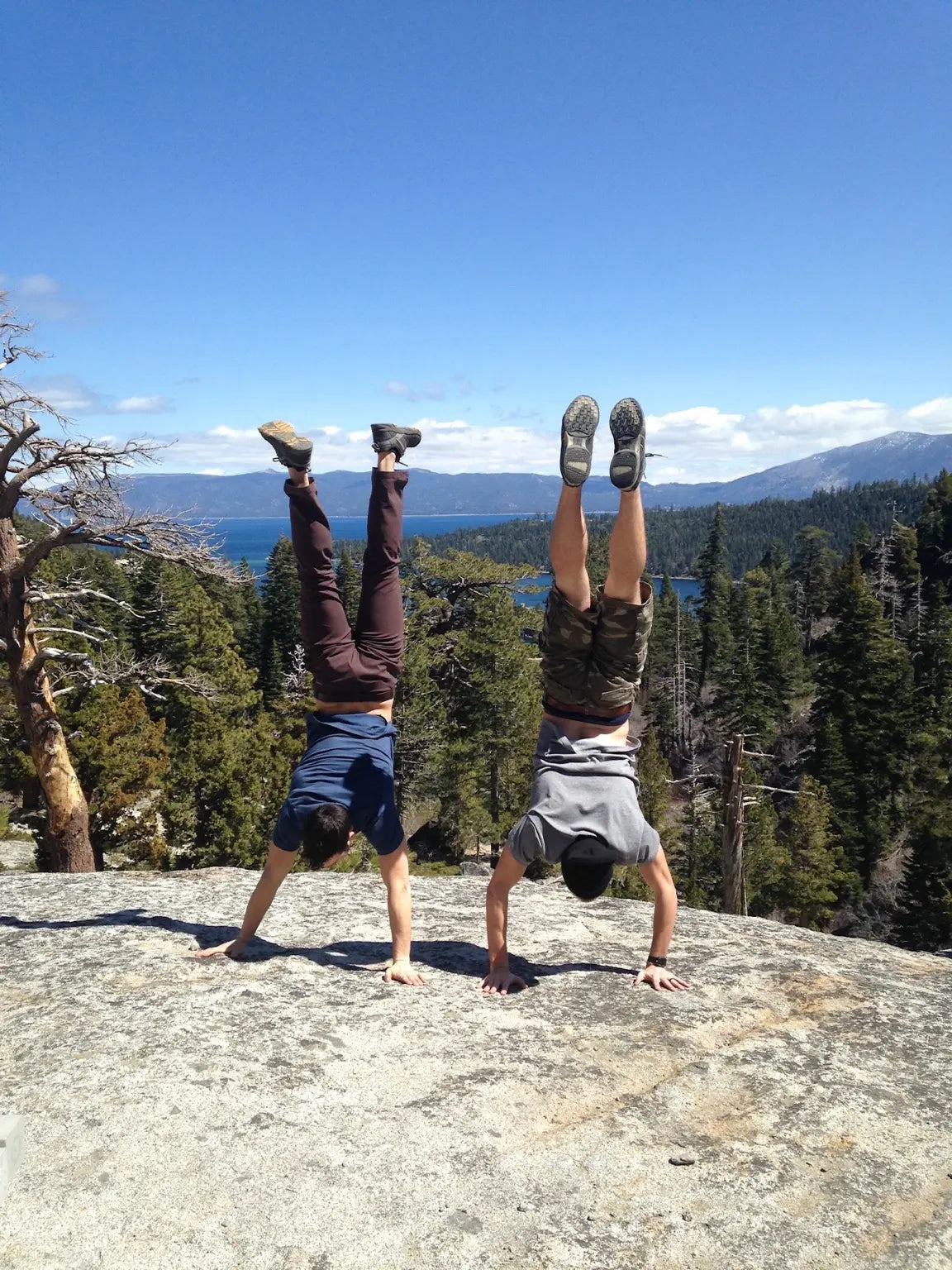 Friends doing handstands together on a mountain overlook
